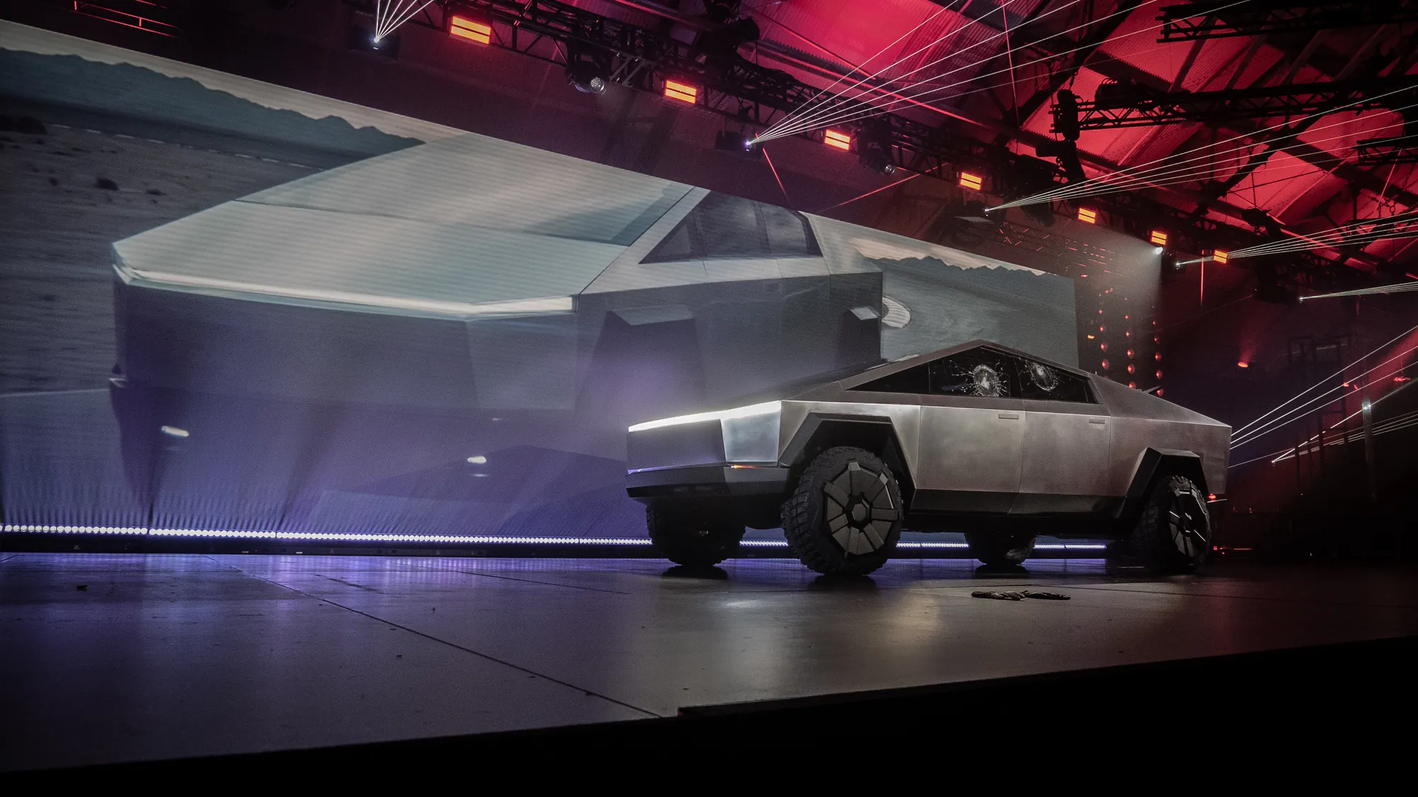 Tesla Cybertruck reveal on a dark stage with red and violet light