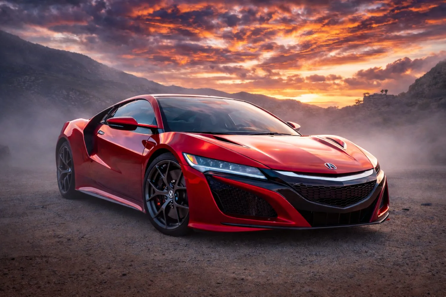 Red Acura NSX under a fiery golden-hour sky